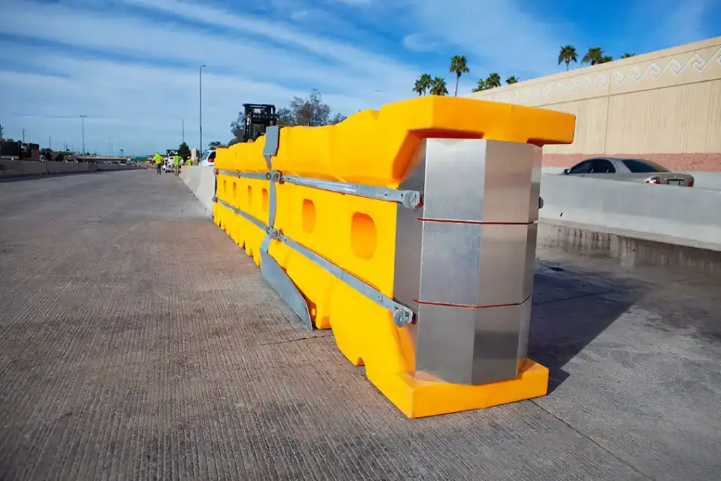 Atenuador de impacto modular amarillo instalado en el extremo de una barrera de concreto en una vía de alto tránsito